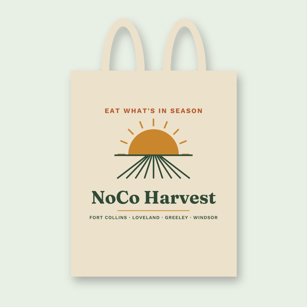 Natural cotton tote printed with a sunrise over farm rows and the words Eat What's In Season
